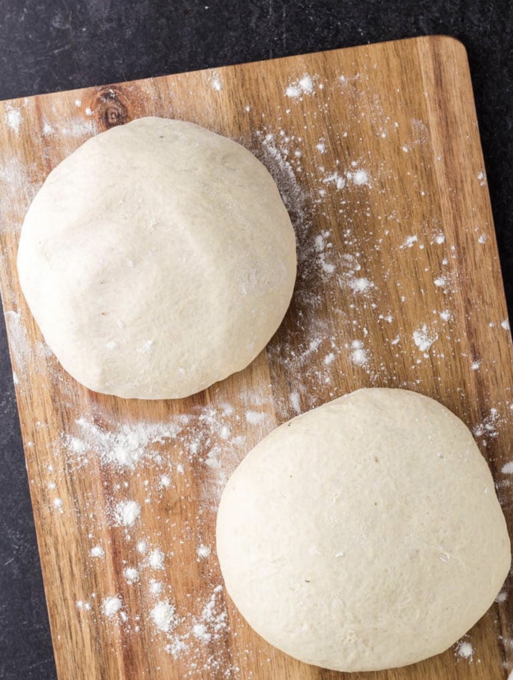 Flash-frozen Italian artisan pizza dough balls on wooden board